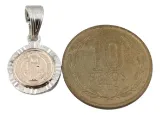 Medalla San Benito para Bebé siendo comparada con una moneda de 10 pesos