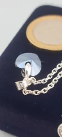 Cristal en forma de corazon con una monedo de 100 pesos chilenos al lado