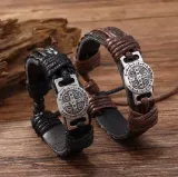 Par de pulseras religiosas San Benito en cuero marrón mostrando detalle del tejido trenzado.