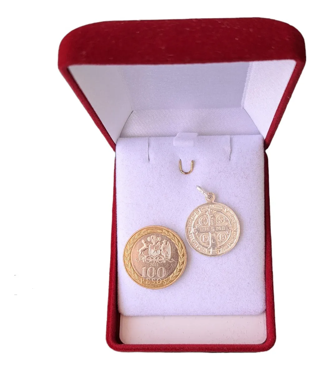 Medalla de protección San Benito 17mm comparada con moneda de 100 pesos.