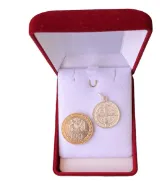 Medalla de protección San Benito 17mm comparada con moneda de 100 pesos.